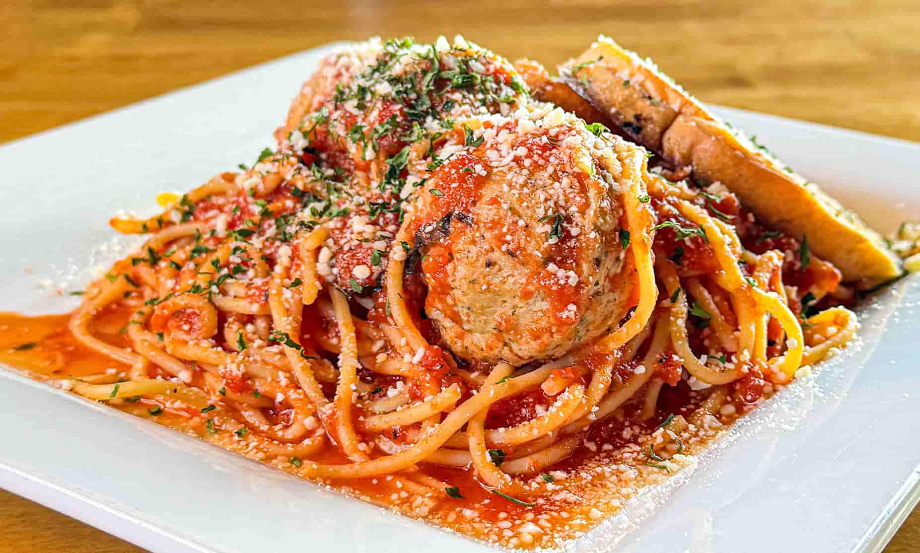 Spaghetti and Meatballs with red sauce and topped with cheese' with side of garlic bread Spaghetti and Meatballs with red sauce and topped with cheese' with side of garlic bread